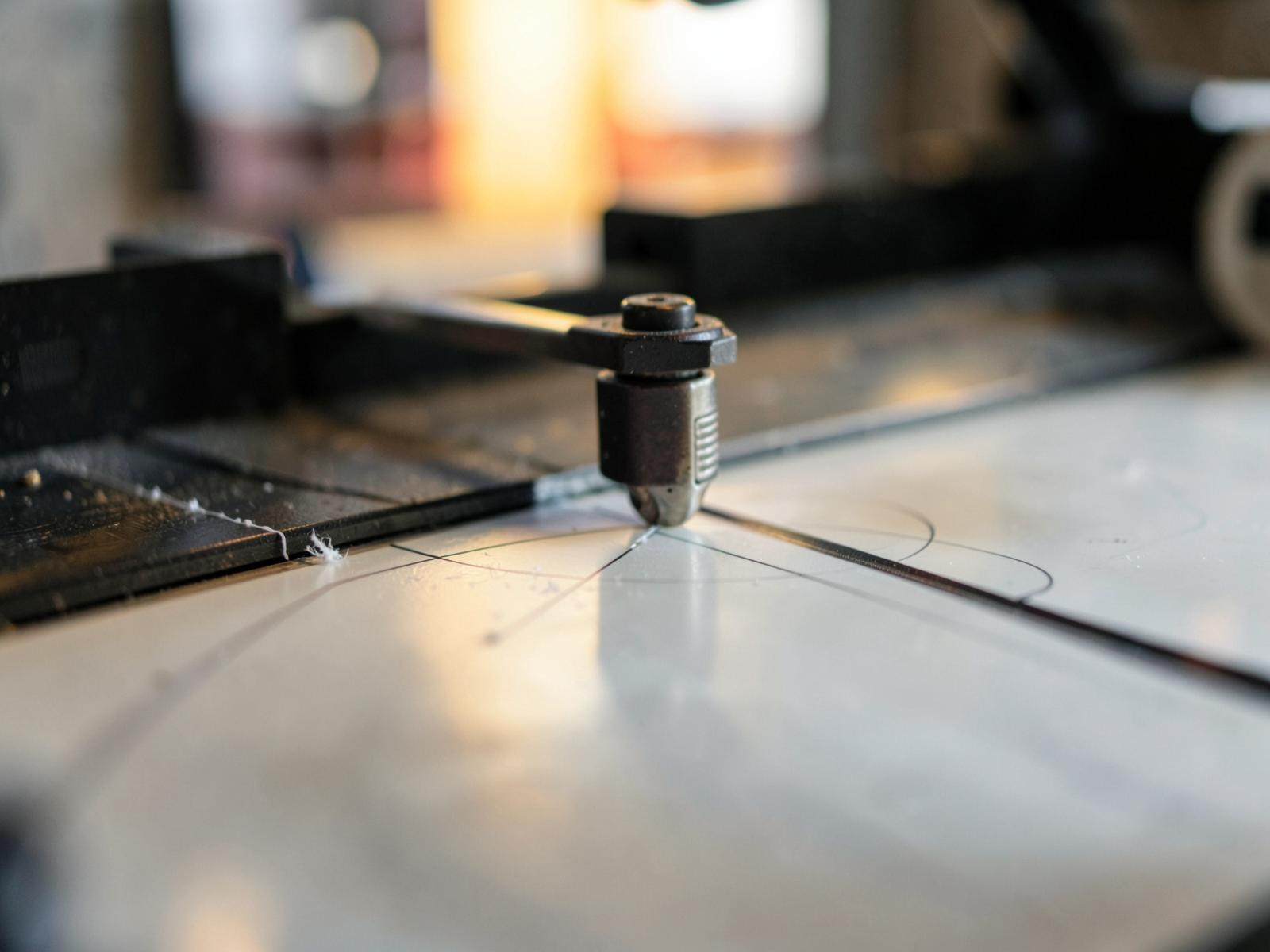 Skärplotterns knivhuvud som skär tunna linjer i vinylfolie